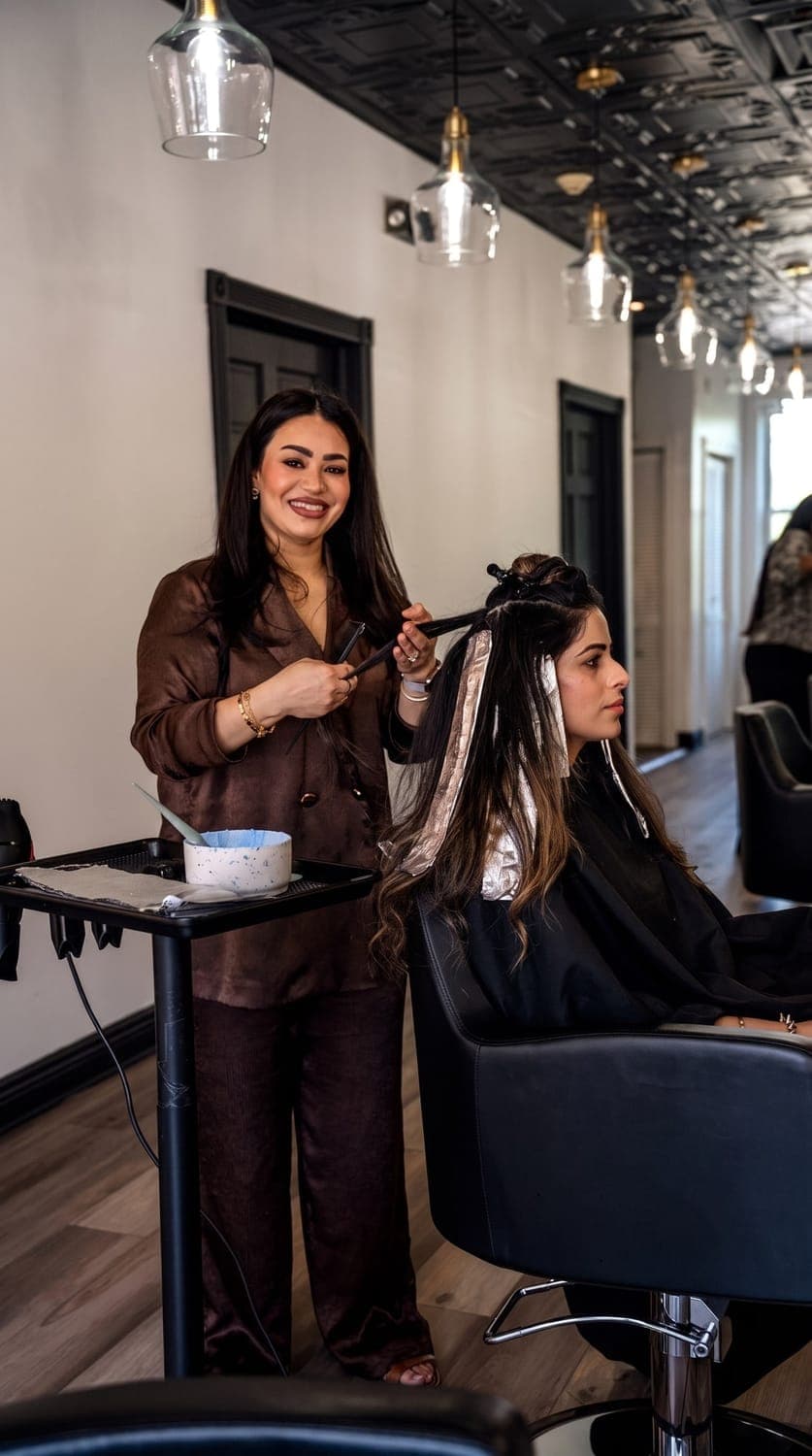 Manijeh foiling a client at her station in the salon