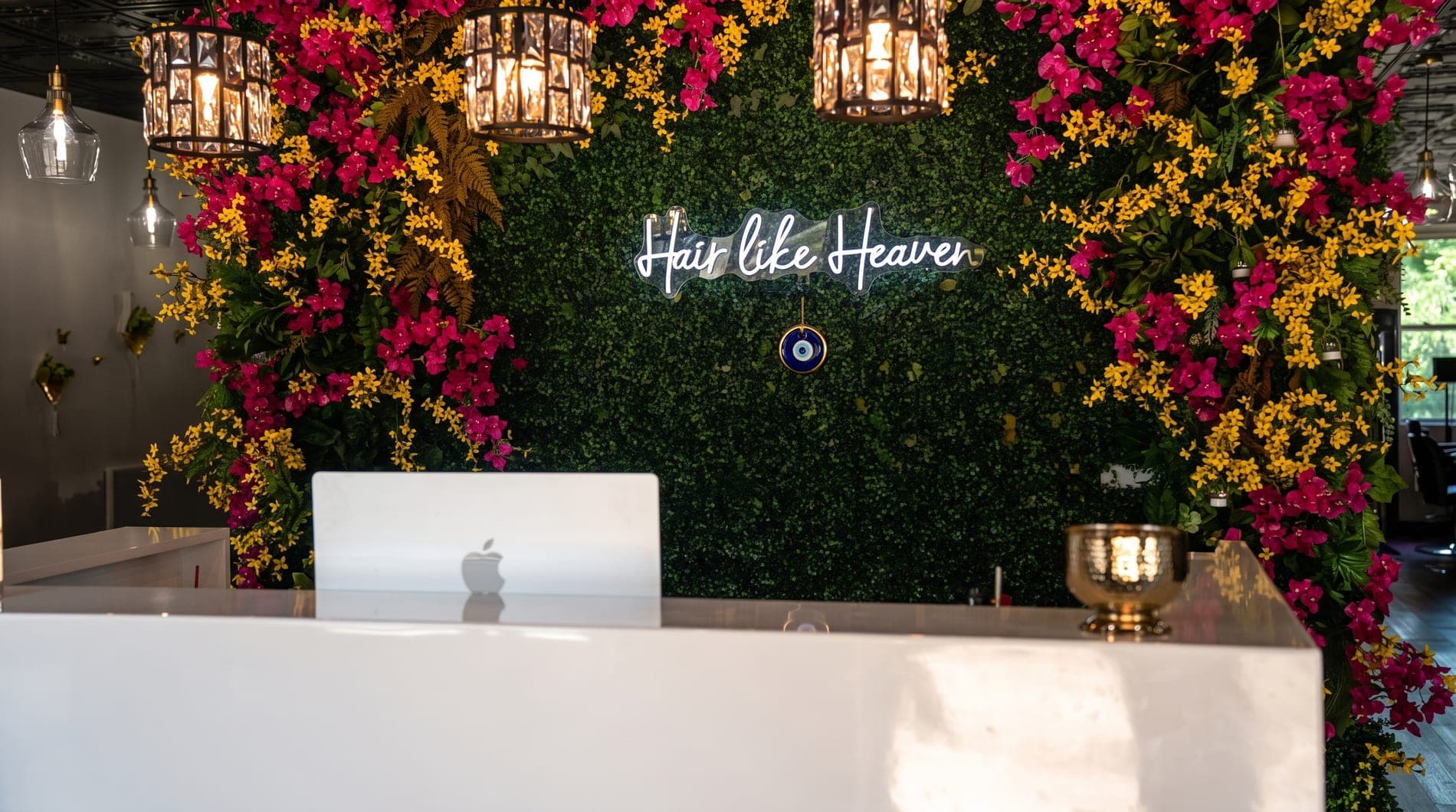 The reception desk under the 'Hair like Heaven' neon
