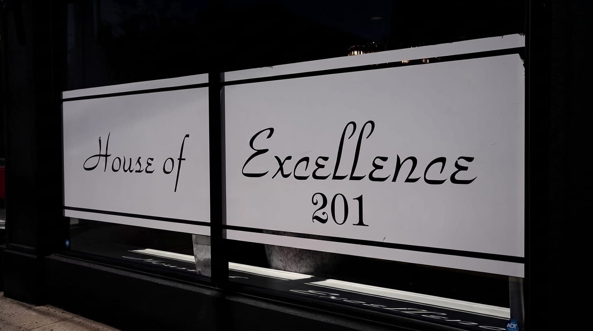 The 'House of Excellence 201' window signage